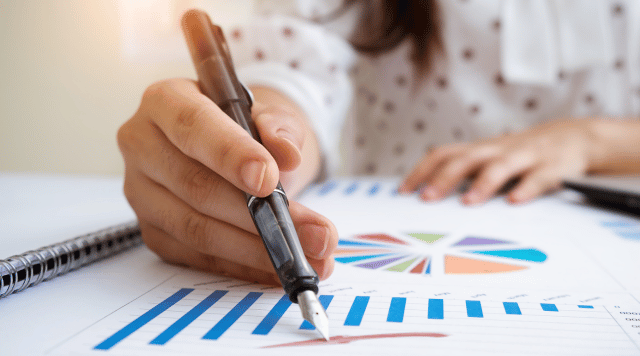 Wyliczanie odsetek na wykresie, jest ręka która wskazuje długopisem wykres