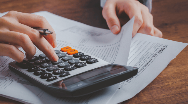 Wyliczanie podatków przy kalkulatorze i kartce papierów