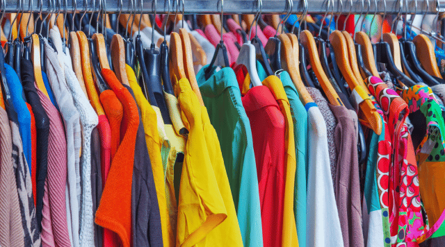 Odzież używana i nowe ubrania wiszące na wieszaku w sklepie