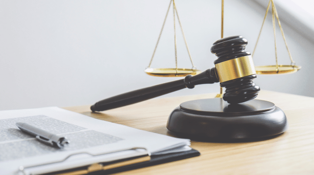 Młotek sędziowski a obok kartka na której jest uchwała o rozwiązaniu spółki