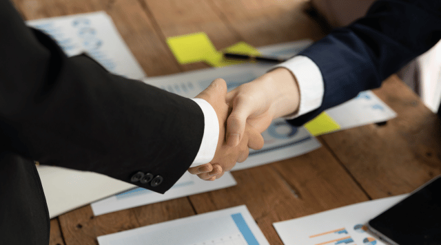 Dwóch mężczyzn podających sobie dłonie celem zlikwidowania spółki