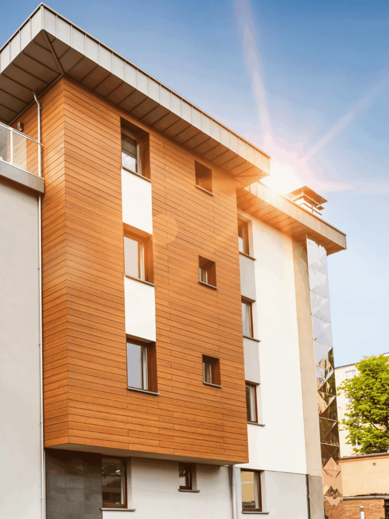 Budynek pomaranczowy z oknami i odbijajacym sie od niego swiatlem