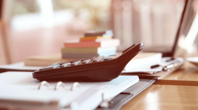 kalkulator na fakturach ustawiony, w tle komputer