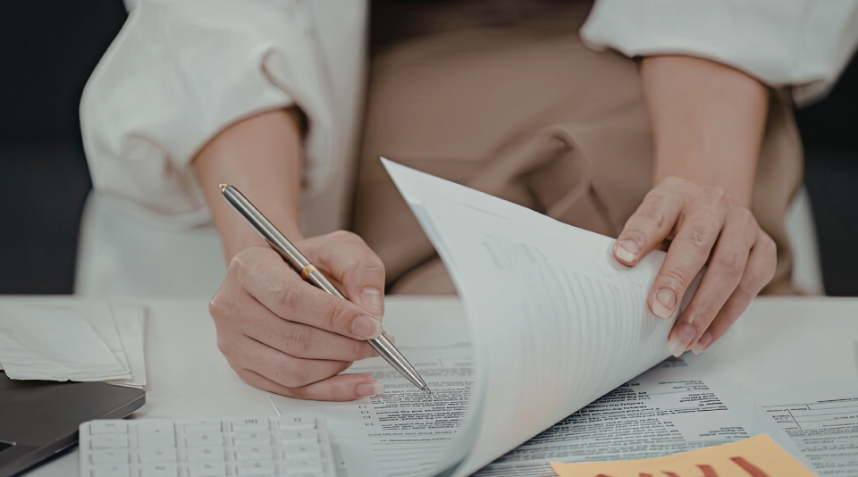 Osoba która sprawdza w zeszycie jak dana firma ma opłacone podatki